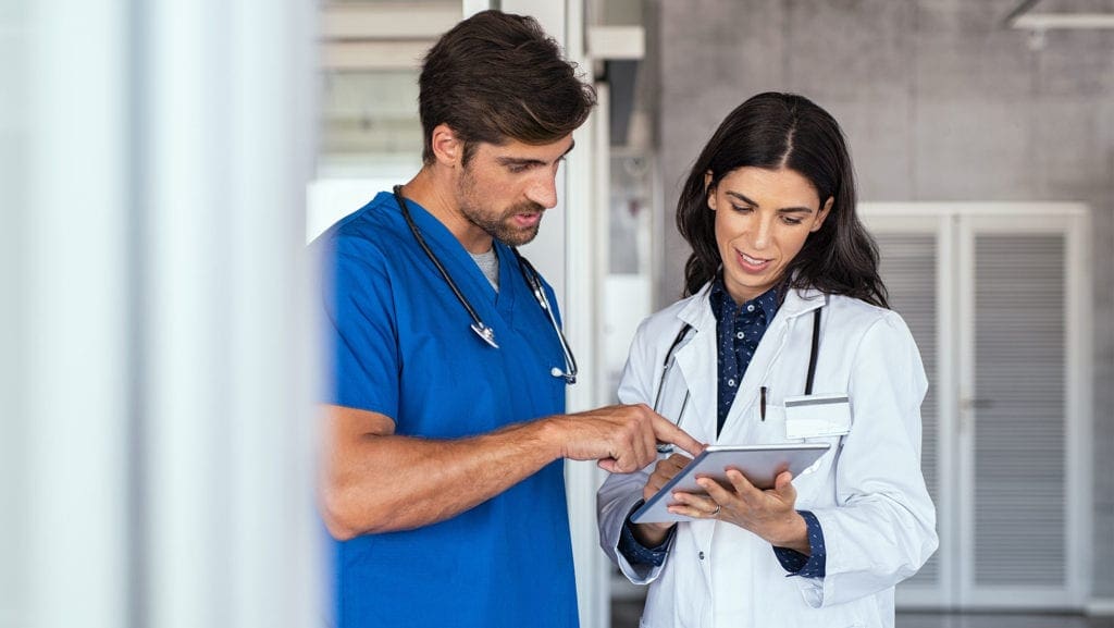 Male nurse and female doctor using a practice management system. 