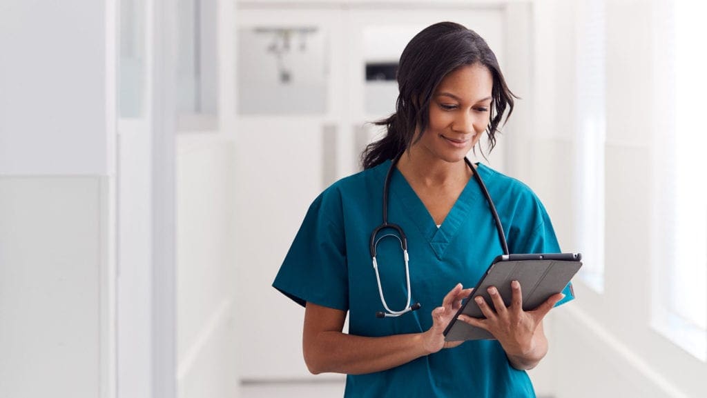 Female nursing using a practice management system via a tablet. 