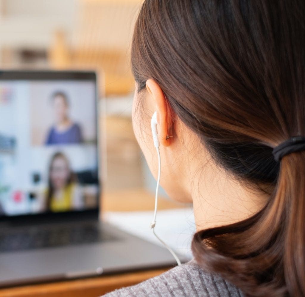 female with headphones in on video call about population health