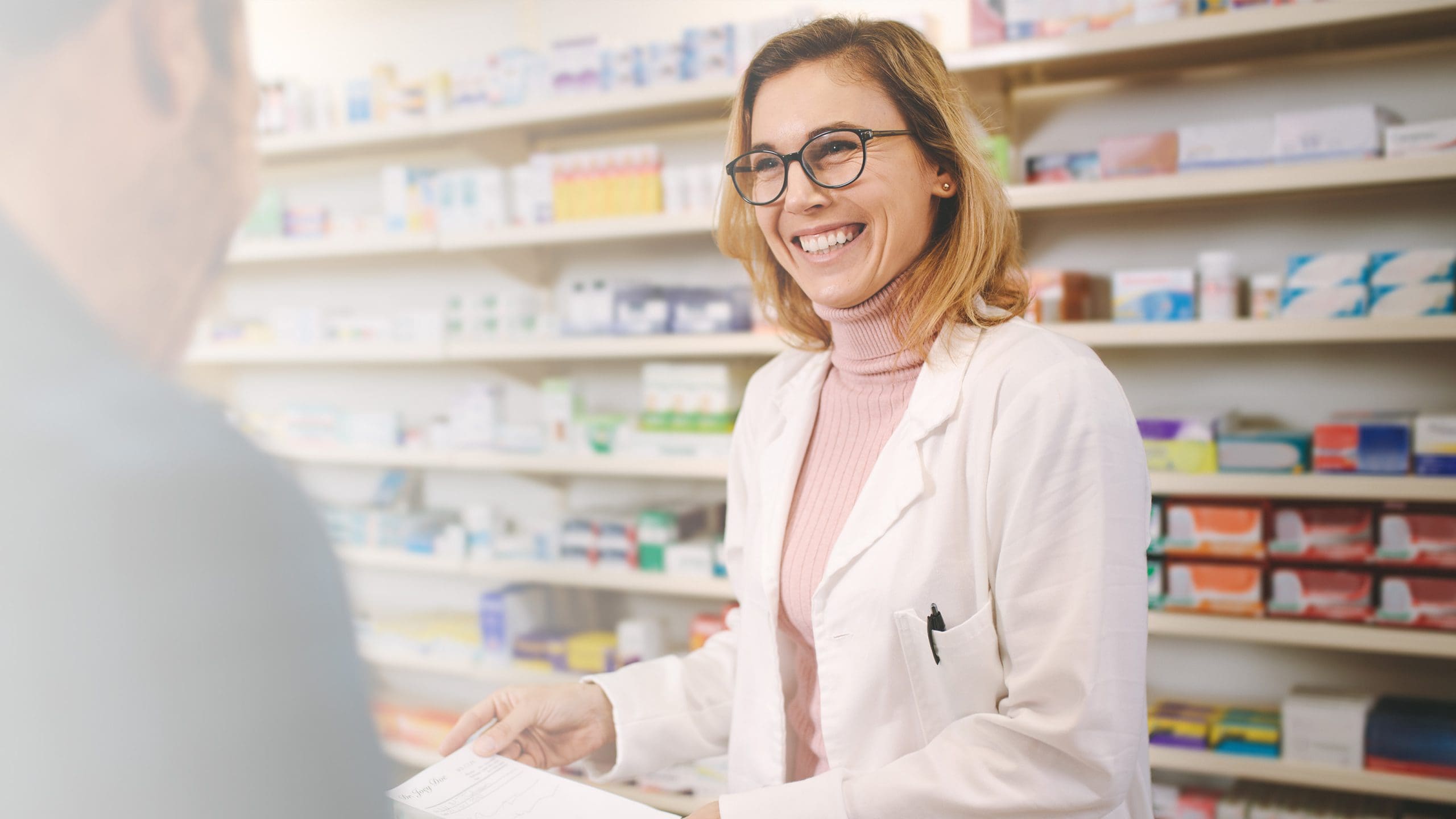 female pharmacist helping a patient using a pharmacy billing solution